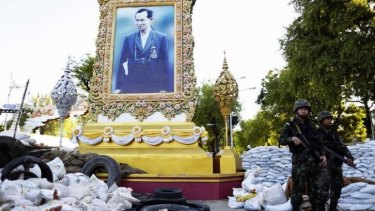New order: Thai soldiers move to dismantle an anti-government protest camp surrounding a portrait of King Bhumibol Adulyadej.