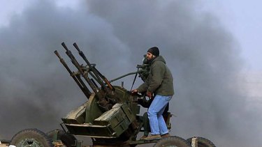 Rebel fighters return fire during shelling by soldiers loyal to Libyan leader Muammar Gaddafi in a battle near Ras Lanuf.
