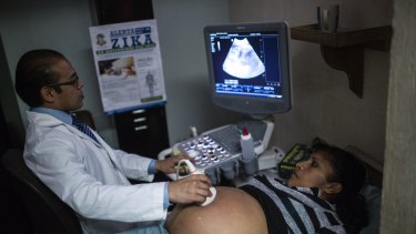 A poster with information about the Zika virus hangs on a wall as a pregnant woman undergoes an ultrasound treatment at the Social Security Institute maternity ward in Guatemala.
