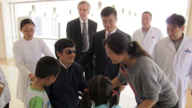 Reunited ... Chen Guangcheng greets his wife, Yan Weijing, and children at Beijing's Chaoyang Hospital.