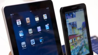 A journalist compares the new Samsung Galaxy Tab, right, with the Apple iPad, left.