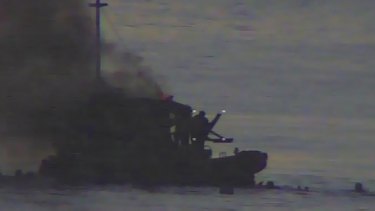 Video footage shows the SIEV 36 on fire and several people in the water.