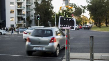 A sign and flowers at the intersection of Barry Dr and Northbourne Ave for well-known Canberra window-washer, Lindsay.