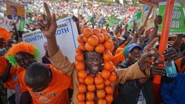 A supporter of Opposition Leader Raila Odinga wears a headdress of oranges, the party's symbol and colour.