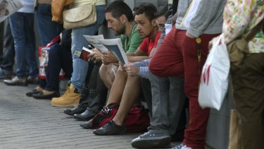 People wait outside an unemployment office in Madrid as the number of people out of work remained at around 4.7 million.
