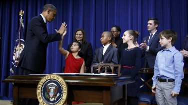 President Obama high-fives eight-year-old Hinna Zejah, one of four children who had written to him asking for action after the Sandy Hook massacre.