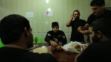 'We have a creed': Imam Ali Brigade fighters take their evening meal together.