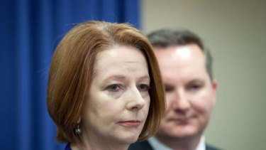Hammered ... Julia Gillard and Chris Bowen, the Minister for Immigration, at a news conference in Brisbane yesterday.