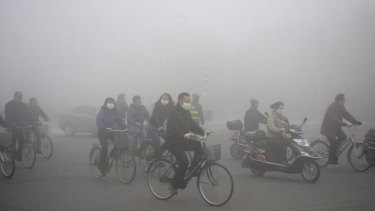 People ride through the smog in Daqing, Heilongjiang province.