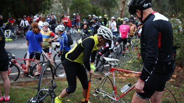 A cyclist fixes a puncture after hitting a tack on Kew Boulevard - during a protest involving over 1000 riders protesting against someone laying tacks on the road.