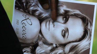 A relative of the late South African model Reeva Steenkamp holds the funeral ceremony program.