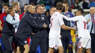 Serbian players, in red shirts, clash with England players, after their under-21s clash.