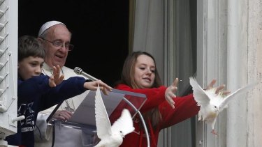 Birds of peace: Pope Francis and two children release the doves.