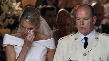 All white ... Princess Charlene dries her eyes as she and husband Prince Albert leave their marriage blessing.