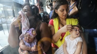 Mothers Jusikelly (R) and Inabela hold their daughters Luhandra (R) and Graziella, both born with microcephaly, a birth defect linked to the Zika virus.