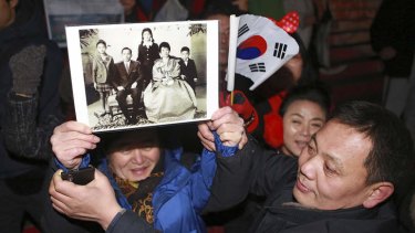 Family tradition ... supporters of Ms Park celebrate while holding a photo of her late father and mother, both assassinated.