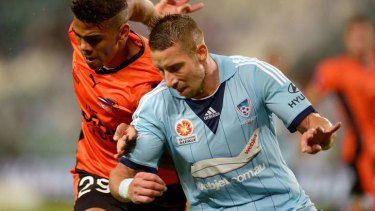 Kwame Yeboah of the Roar and Nikola Petkovic of Sydney FC compete for the ball.