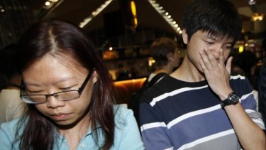People, who said they believed their relatives were on Malaysia Airlines flight MH17, react as they wait for more information about the plane at Kuala Lumpur International Airport.