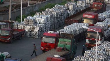 Workers walk through an aluminium ingots depot in Wuxi, Jiangsu province.