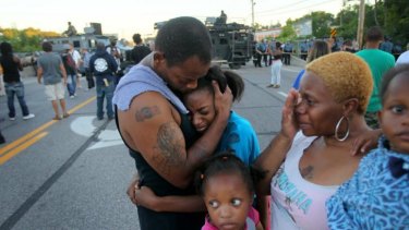 Terrell Williams hugs his daughter Sharell, 9, while standing with his wife, Shamika Williams, and daughters Tamika, 6, and Sharell, 2, on Wednesday in Ferguson.