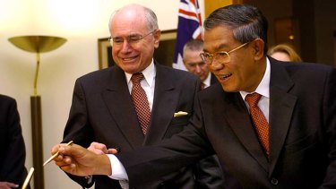 Leading questions: John Howard watches Cambodian Prime Minister Hun Sen sign the visitors' book at Parliament House in 2006.