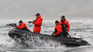 Russian Prime Minister Vladimir Putin aims a crossbow at a whale to take skin samples off Russia's Far Eastern coast.