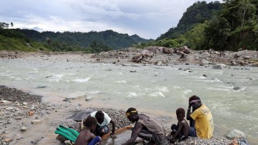 A family panning gold in the polluted Jaba river flowing from Panguna copper mine.