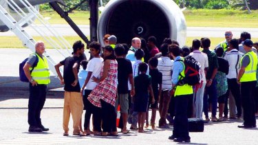 Tamil asylum seekers board an aeroplane on Cocos Island bound for the Australian mainland.