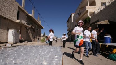 A competitor sports the Irish flag near a drinks station during this year's Palestine Marathon.