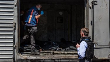 Dutch forensic experts inspect the bodies of MH17 victims stored on a train in Ukraine.