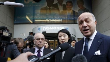 French Foreign Affairs Minister Laurent Fabius (right), Interior minister Bernard Cazeneuve and Culture Minister Fleur Pellerin are surrounded by media as they leave French television network TV5Monde headquarters in Paris.