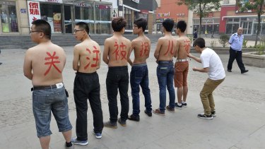Depending on their aims, activists can be targeted and harassed in China. These men, trying to draw attention to child trafficking are painted with a slogan in China's Shanxi province in 2013.