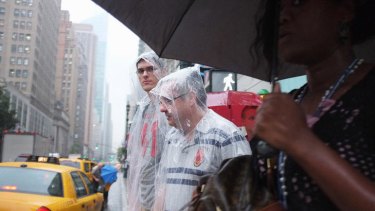 Pedestrians try to keep dry as Hurricane Irene heads east.