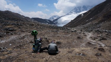 Members of the Google Street View project sit with the camera used to capture project footage in Nepal's Khumbu region. Google's Street View virtual tour of the rugged Everest region follows sky-high trails and suspension bridges.