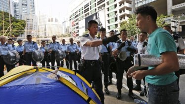 Police ask a protester to leave his camp on a main road in Hong Kong's Central district on Tuesday.