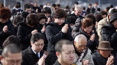 People take part in a moment of silence at 2.46pm during a ceremony in Ofunato.