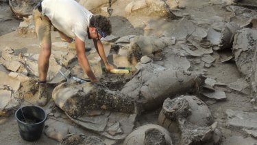 Good drop ... George Washington alumnus Zach Dunseth carefully removes dirt from ancient wine jars while excavating the ruins of a recently discovered wine cellar in a Canaanite palace from 1700 B.C. in Israel.