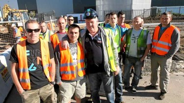Promised higher wages: The workers with union spokesman Brian Parker, centre.