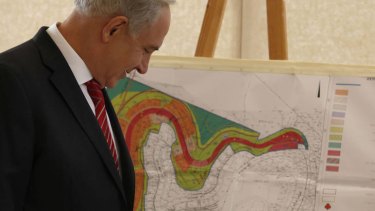 Facts on the ground ... Mr Netanyahu looks at a map of the area where Israel plans to build 800 units in Gilo.