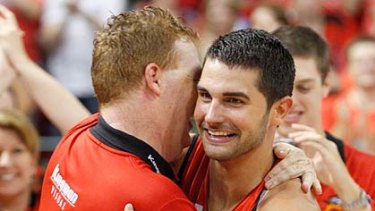 Wildcats' newest star Kevin Lisch is embraced by coach Rob Beveridge after winning the NBL championship in Perth last night.
