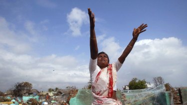 A local fisherwoman gestures for assistance to a hovering navy helicopter in the southern Indian state of Tamil Nadu after the boxing day Tsunami in 2004. 