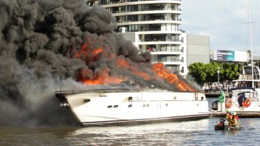 Marine response officers try in vain to control a fire on a cabin cruiser at Docklands.