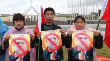 Members of the Chinese community protest against Clive Palmer outside Parliament House on Tuesday.
