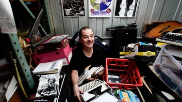 Zine fan Luke Sinclair in his storage shed surrounded by his collection.