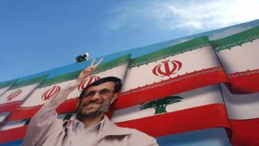 Star power ... a workman puts the finishing touches on a billboard of the Iranian President in a stadium in southern Lebanon.