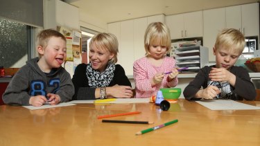 Abigail Elliott draws with her children Willem, left, Imogen and Fynley. The family has faced tough choices in finding schools for Willem. 