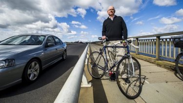 David Mann with his bent bike near where he fell over the railing into the path of traffic on the Commonwealth Avenue bridge.
