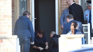 Police at the scene of one of the raids in Guildford.