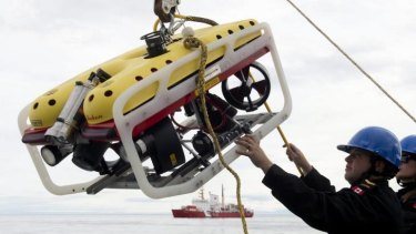 A crew member of the HMCS Kingston loads an remote underwater vehicle part of the Victoria Strait Expedition, west of Pond Inlet on the Eclipse Sound.