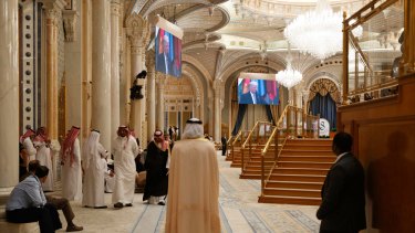 People watch US President Donald Trump on screens inside the King Abdulaziz Conference Centre in Riyadh.